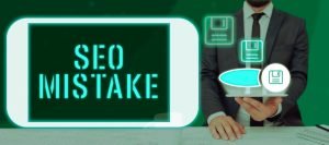 Image showing a person in a suit holding a tablet with the words 'SEO MISTAKE' displayed prominently on the screen. The background is green, and there are several floating icons of floppy disks, symbolizing data storage or saving, around the tablet.